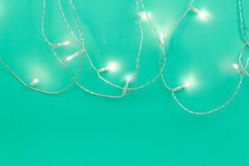 turquoise background with light from a garland with space for writing