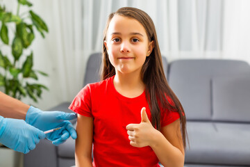 Little girl in the doctor's office is vaccinated. Syringe with vaccine against covid-19...