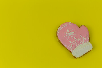 Christmas gingerbread covered with bright icing on a yellow uniform background