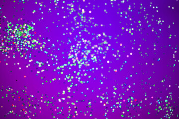 silver sparkles on a bright purple background. selective focus, blur