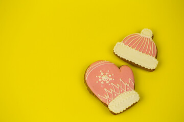 Christmas gingerbread covered with bright icing on a yellow uniform background