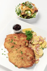 german breaded organic pork schnitzel with bacon fried potatoes