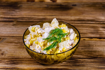 Festive salad with chicken breast, canned pineapple, cheese, sweet corn and mayonnaise on wooden table