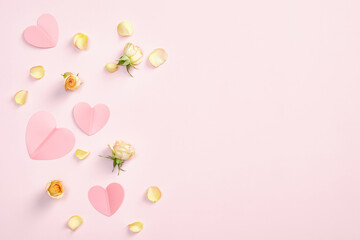Flat lay composition with paper hearts, rose flowers and petals on pink background. Romantic, love, Valentines Day concept. Top view with copy space.