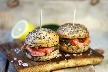Salmon burgers with avocado paste on healthy buns with seeds. Fish sandwiches. Healthy diet. Keto burgers.