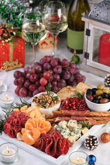 Delicacy assorted appetizer platter of salami and cheese,  grissini wrapped in Parma ham, olives and citrus fruits. An original antipasto serving for a Christmas party.