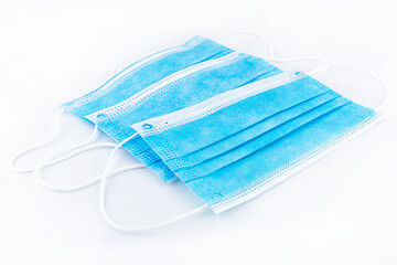 Fototapeta premium Three blue surgical masks for personal protection against the virus, isolated on a white background.
