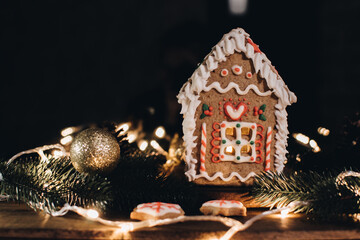 Scandinavian hygge styled Christmas composition. Cozy winter homely scene with gingerbread house for Holidays. Christmas cookies.