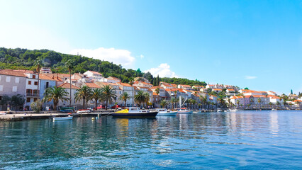 Panoramic view of Korcula coast with mountains, houses and boats on the harbor