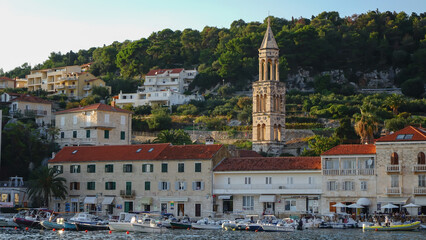 Panoramic view of Hvar town with boats docked in the harbor with the bell tower of Hvar Cathedral