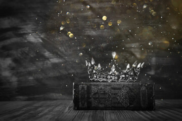 low key image of beautiful queen/king crown on old book. vintage filtered. fantasy medieval period....