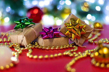 Christmas gifts with blur Christmas balls and beads on bokeh background. Christmas background or Christmas card. New Year or Xmas concept.
