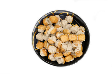 Fried Fish Tofu placed in a black plate isolated on white background.