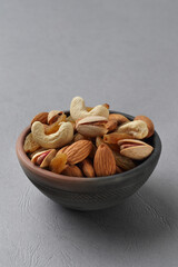 Assorted nuts in a clay bowl. 