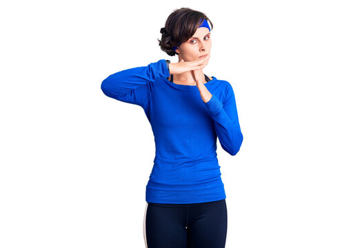 Beautiful young woman with short hair wearing training workout clothes doing time out gesture with hands, frustrated and serious face