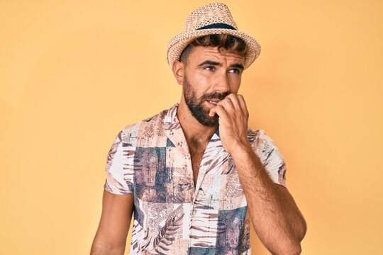 Young hispanic man wearing summer hat looking stressed and nervous with hands on mouth biting nails. anxiety problem.