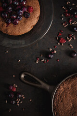 Brownie on plate with berries and cast iron skillet
