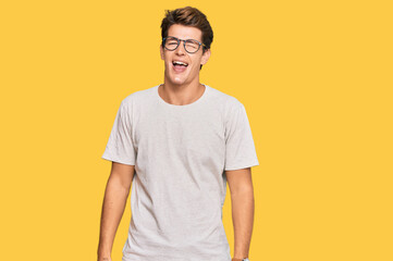 Handsome caucasian man wearing casual clothes and glasses winking looking at the camera with sexy...