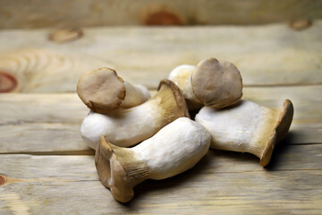 Selective focus. Macro. Raw eringi mushrooms on a wooden surface.