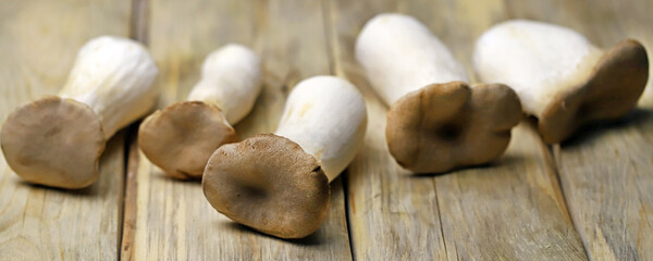 Selective focus. Macro. Raw eringi mushrooms on a wooden surface.