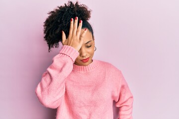 Young african american girl wearing casual clothes surprised with hand on head for mistake,...