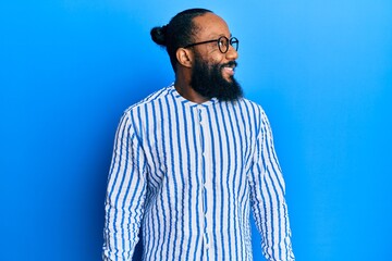 Young african american man wearing business style looking to side, relax profile pose with natural face and confident smile.