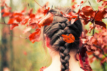 Girl with braid in leaves 