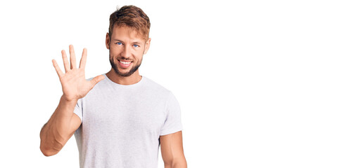 Young caucasian man wearing casual white tshirt showing and pointing up with fingers number five while smiling confident and happy.