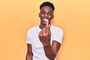 Young african american man wearing casual clothes beckoning come here gesture with hand inviting welcoming happy and smiling