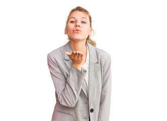 Young beautiful blonde woman wearing elegant jacket looking at the camera blowing a kiss with hand on air being lovely and sexy. love expression.