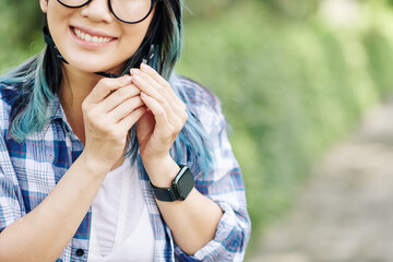 Smiling young woman fastening bicycle helmet before ride