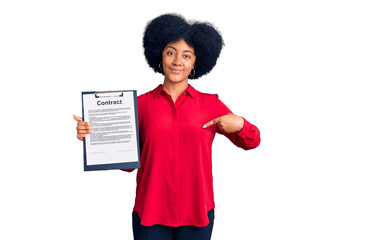 Young african american girl holding clipboard with contract document pointing finger to one self smiling happy and proud