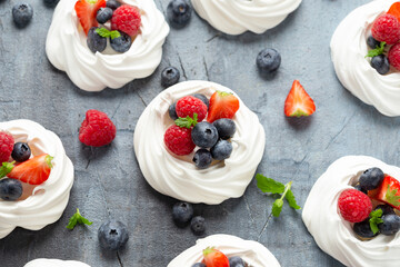 Meringue nest mini pavlova cake with fresh berries strawberry blueberry raspberry and mint for healthy desert.
