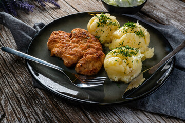 Pork chop served with mashed potatoes and cucumber salad.