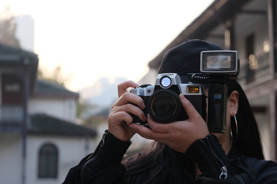 medium close up one young woman using digital camera outdoor