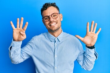 Young hispanic man wearing casual clothes and glasses showing and pointing up with fingers number...