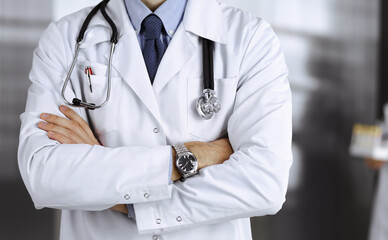 Unknown male doctor in protective mask standing with arms crossed in clinic. Medicine concept during Coronavirus pandemic. Covid 2019