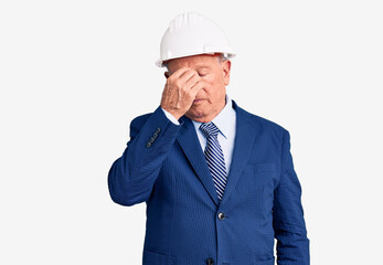 Senior handsome grey-haired man wearing suit and architect hardhat tired rubbing nose and eyes feeling fatigue and headache. stress and frustration concept.