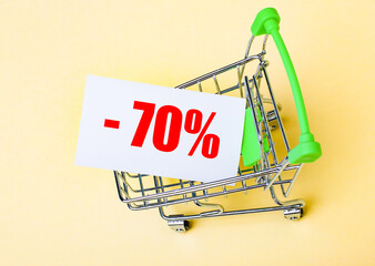 The card with the words minus seventy percent is in the shopping cart. Marketing concept