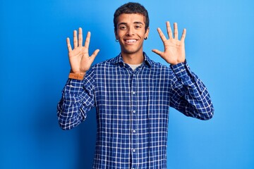 Young african amercian man wearing casual clothes showing and pointing up with fingers number ten while smiling confident and happy.