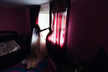 bride in beautiful wedding dress in bedroom open the curtains. b