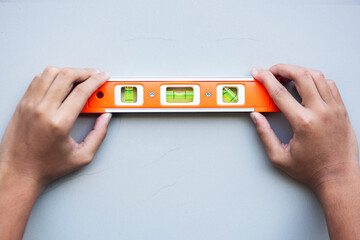 Man  hand  using a water level gauge to measure the cracked wall