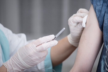 Close-up hands,nurses are vaccinations to patients using the syringe.Doctor vaccinating women in...