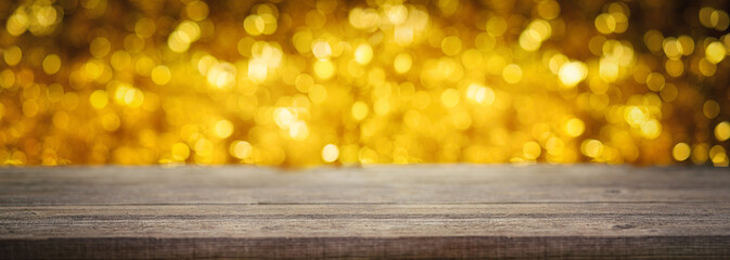 Blurred empty wood table top pattern on abstract shiny bokeh gold background. Can be used for...