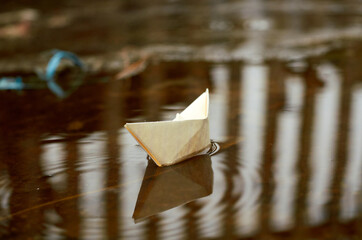 Photo of paper boat in a puddle