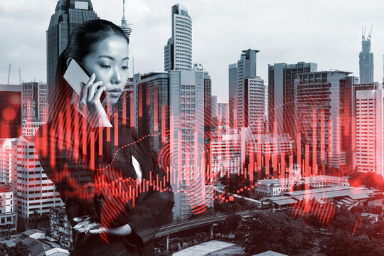Attractive Asian businesswoman trader processing conference call to forecast the capital market behavior. Concept of trading strategy. Forex chart. Kuala Lumpur. Double exposure. - Powered by Adobe