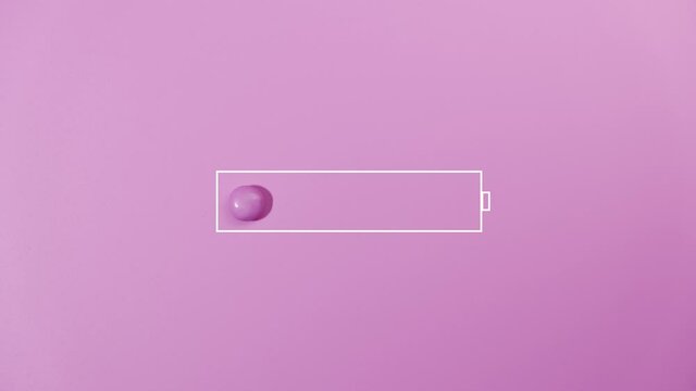 Charging battery indicator of sweet candies on pink background.
