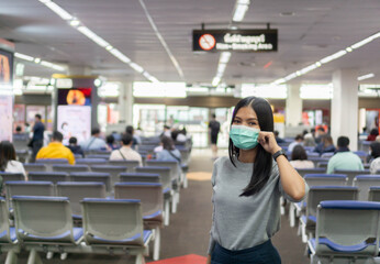 Traveling Asian women at the airport and wearing a mask to prevent the Coronavirus 19 Before boarding the plane.