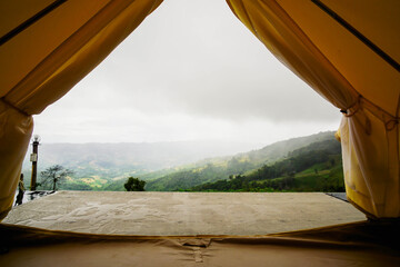 The morning atmosphere of the tent after the rain, the front view is a mountain covered with clouds and morning mist.