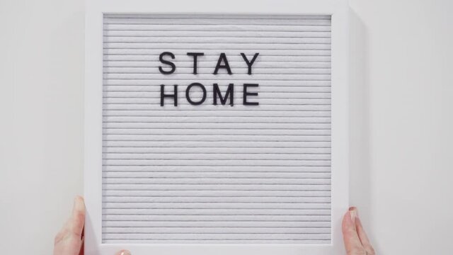 STAY HOME sign on message board with a blue medical mask.